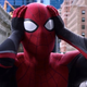 Tom Holland as Spider-Man, staring at a news screen with his head in his hands and shocked.
